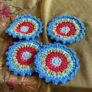 Hand crocheted Mandala coasters in turquoise, green, reddish orange
